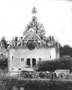 Jüdisches Gotteshaus im Bau. Die Kuppel ist mit Balken hochgezogen, auf der Spitze ein Baum.